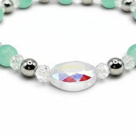Handmade by Erika Liesel stretch bracelet with seafoam green glass beads, crystal accents, and iridescent centerpiece.
