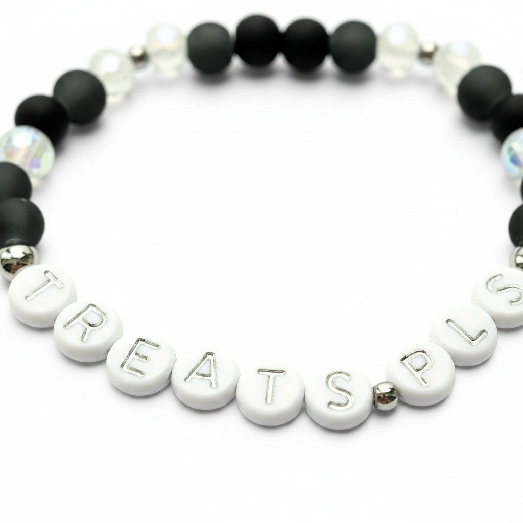 Handmade by Erika Liesel Treats Pls stretch bracelet with matte black glass beads and silver-lettered white beads.