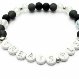 Handmade by Erika Liesel Treats Pls stretch bracelet with matte black glass beads and silver-lettered white beads.