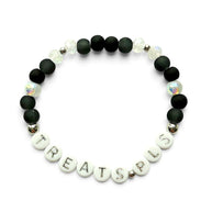 Handmade by Erika Liesel stretch bracelet with matte black beads, iridescent crystals, and TREATS PLS letter beads.
