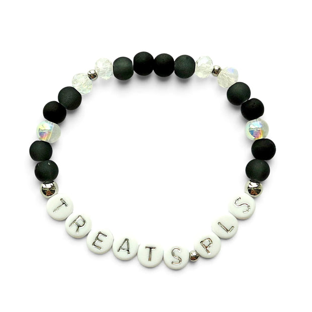Handmade by Erika Liesel stretch bracelet with matte black beads, iridescent crystals, and TREATS PLS letter beads.
