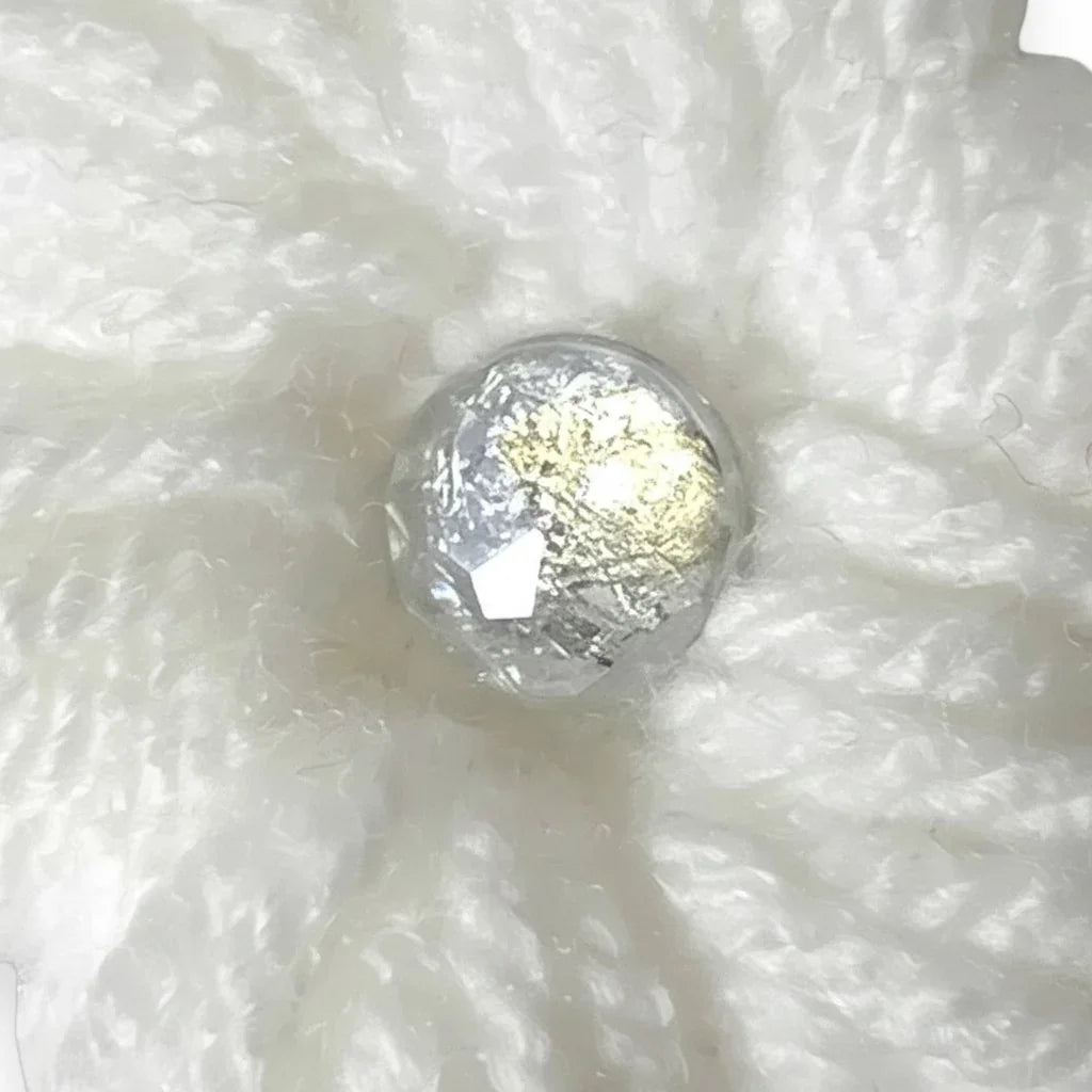 Handmade by Erika Liesel white crochet flower clip with a shimmering center accent for seasonal gnome decor.
