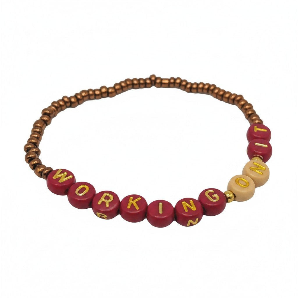 Handmade by Erika Liesel Working On It stretch bracelet with 4mm glass beads and gold-foil letter beads