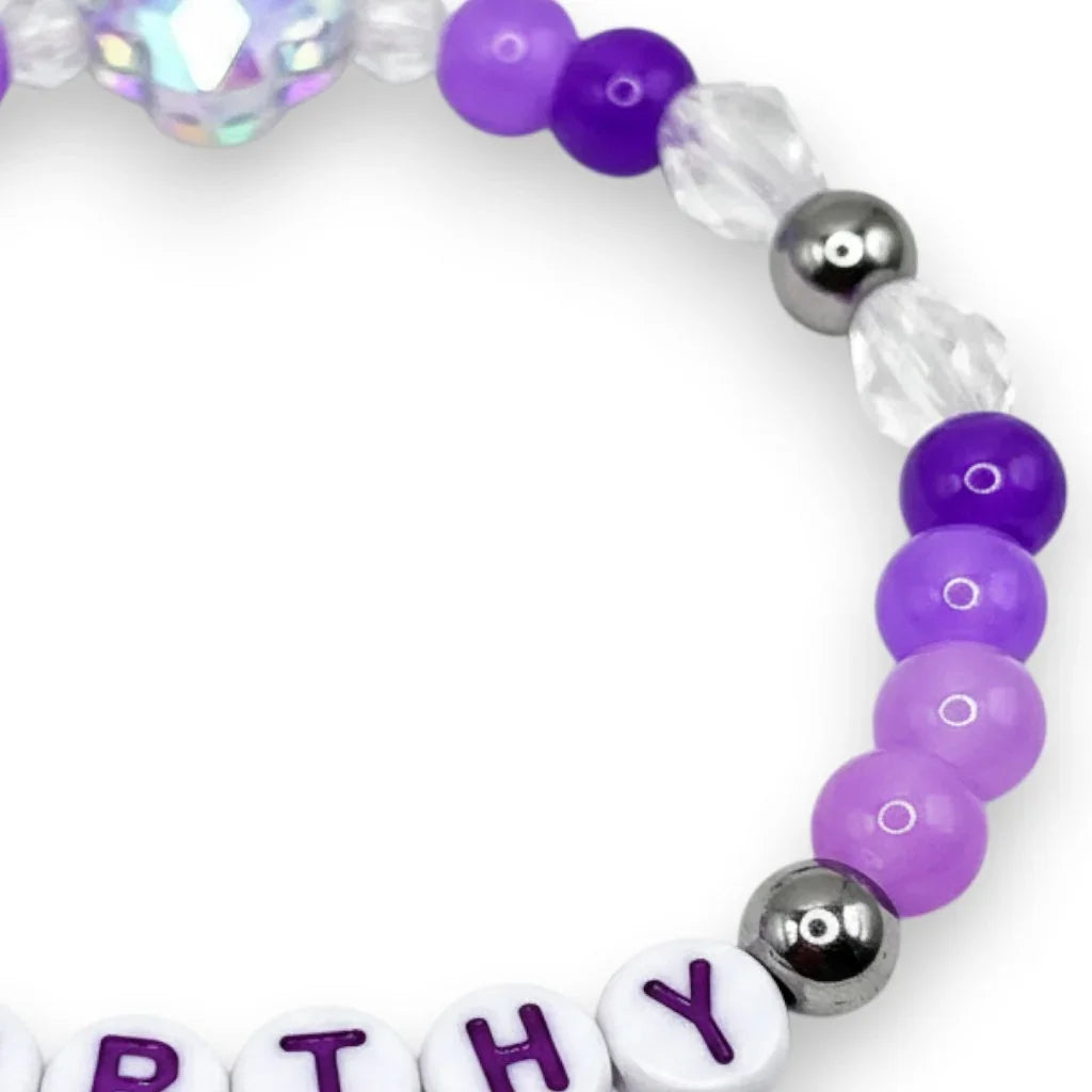 Handmade by Erika Liesel Worthy stretch bracelet with purple crystal beads, sterling silver accents, and letter beads.