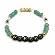 Handmade by Erika Liesel Worthy stretch bracelet featuring green crystal beads, 18K gold accents, and black letter beads.