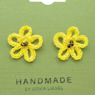 Handmade by Erika Liesel yellow crochet daisy stud earrings with glass bead centers on a green display card.
