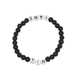 Handmade by Erika Liesel stretch bracelet with black glass beads and white letter beads spelling Yin and Yang