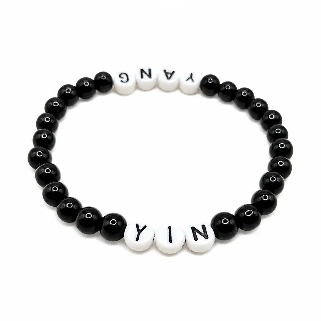 Handmade by Erika Liesel Yin & Yang stretch bracelet with black glass beads and white letter beads on elastic cord.