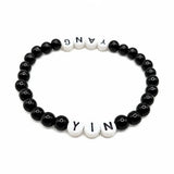 Handmade by Erika Liesel Yin & Yang stretch bracelet with black glass beads and white letter beads on elastic cord.