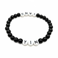 Handmade by Erika Liesel Yin & Yang stretch bracelet with black glass beads and white letter beads on elastic cord.