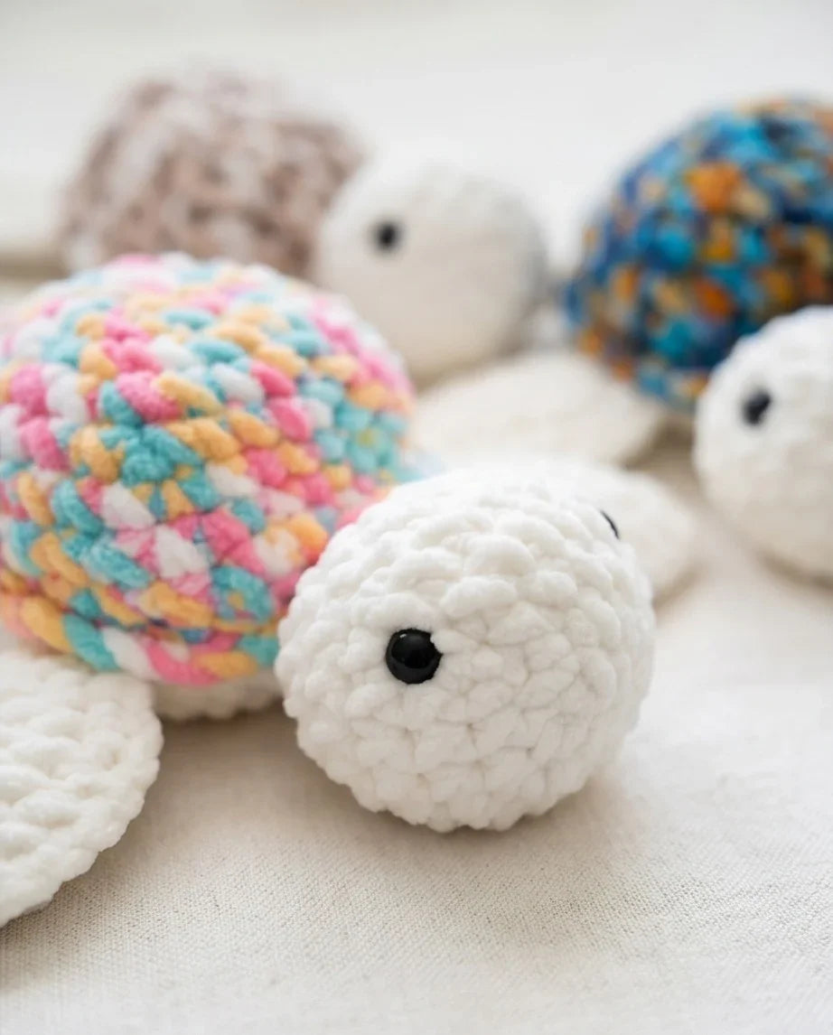 Handmade crochet turtles in pastel and white, cozy amigurumi toys for comfort and play