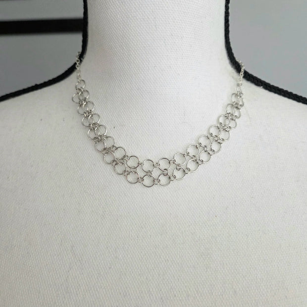 Silver chainmaille necklace with interlocking rings displayed on mannequin, handmade jewelry for everyday wear