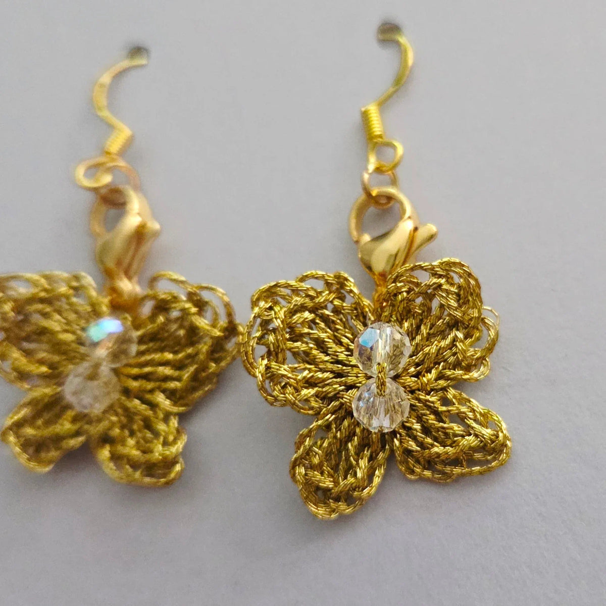 Handmade by Erika Liesel gold crochet butterfly drop earrings with sparkling crystal bead accents.