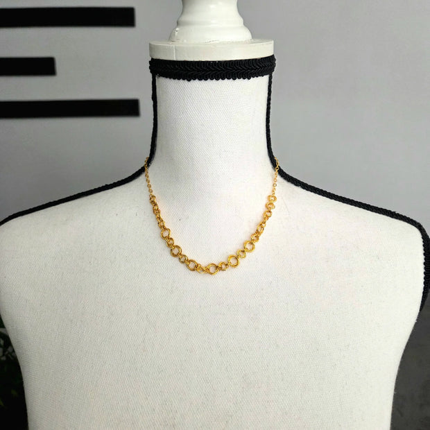 Gold chain necklace on white mannequin with black crochet trim, handmade crochet accessory