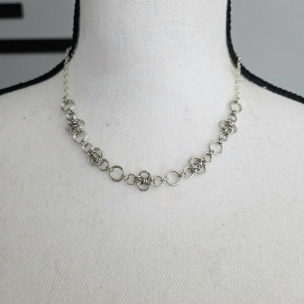 Handmade silver chainmaille necklace with intricate woven rings, displayed on mannequin for elegant everyday wear