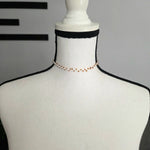 Handmade beaded choker necklace with gold beads on white mannequin, cozy crochet accessory