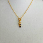 Gold chain necklace with interlocking rings and dark beads, handmade jewelry for everyday wear