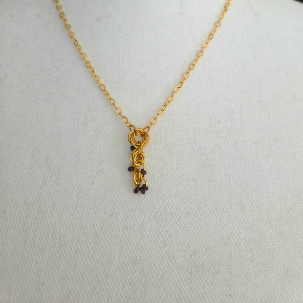 Gold chain necklace with interlocking rings and dark beads, handmade jewelry for everyday wear