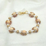 Handmade beaded bracelet with cream wood beads, gold accents, and iridescent seed beads on white cord
