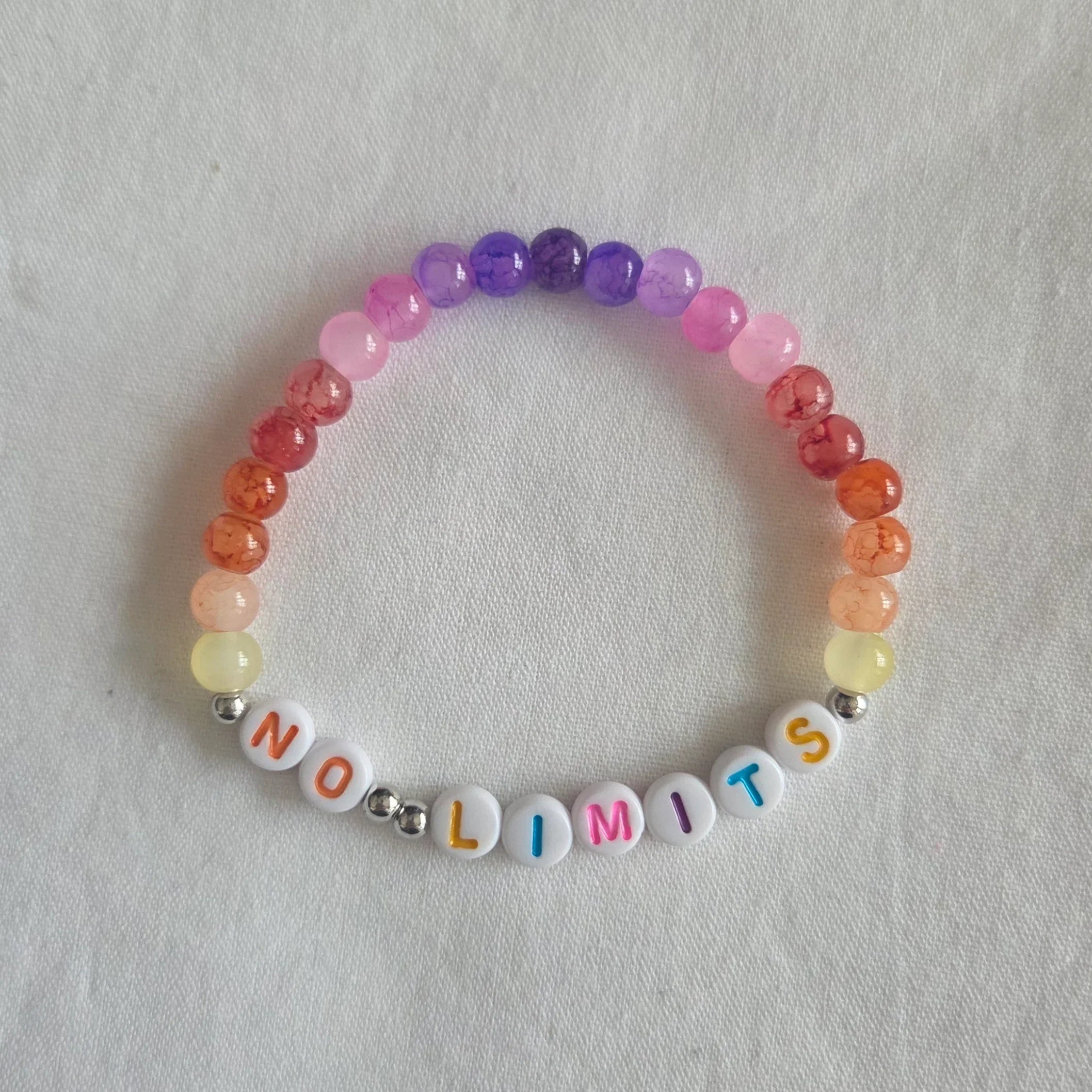 Colorful beaded bracelet with 'NO LIMITS' letter beads, rainbow gradient design