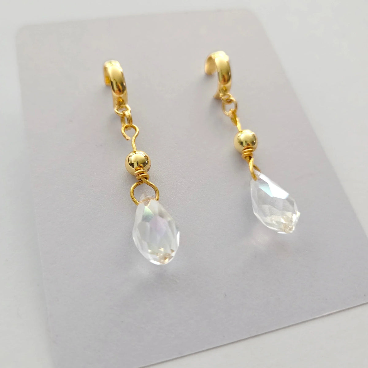 Handmade by Erika Liesel gold half-hoop drop earrings featuring faceted clear crystal beads and 18k gold accents.