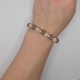 Handmade beaded bracelet with earthy brown and cream wood beads and silver accents worn on wrist