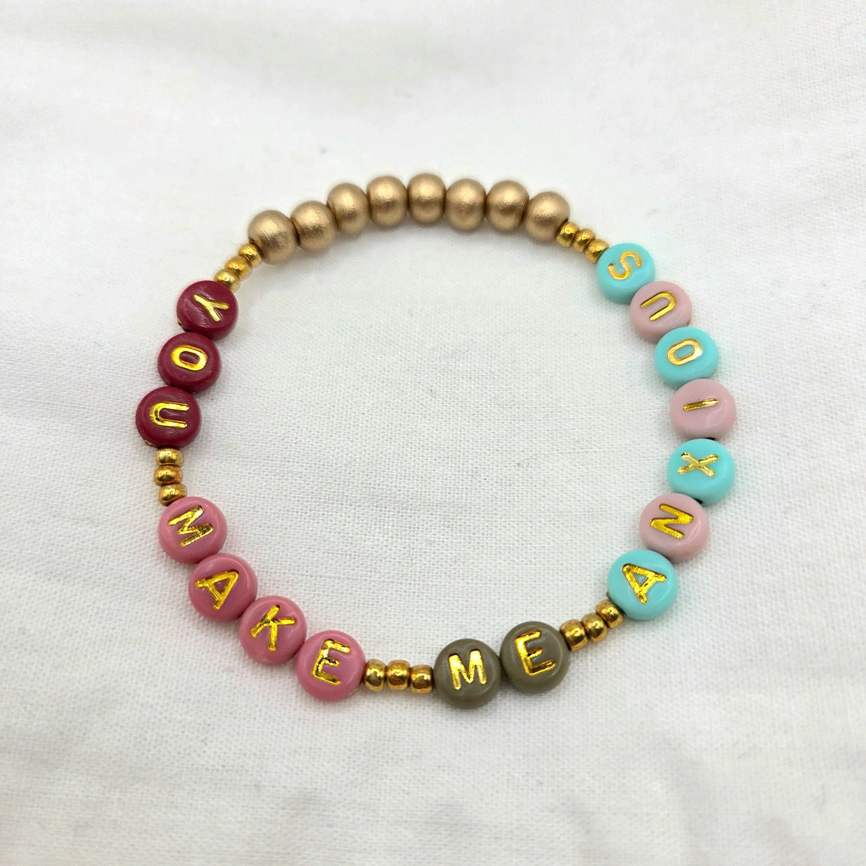Colorful beaded bracelet with 'YOU MAKE ME SMILE' in gold letters, perfect handmade gift for joy and connection.