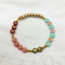 Colorful beaded bracelet with 'YOU MAKE ME SMILE' in gold letters, perfect handmade gift for joy and connection.