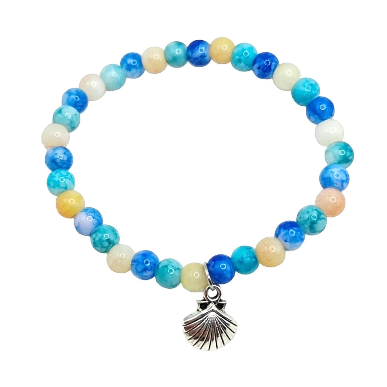 Ocean-themed beaded bracelet with blue, teal, and cream beads plus a silver seashell charm on white fabric