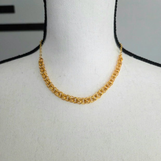 Gold chainmaille necklace on white mannequin, handmade jewelry for everyday wear