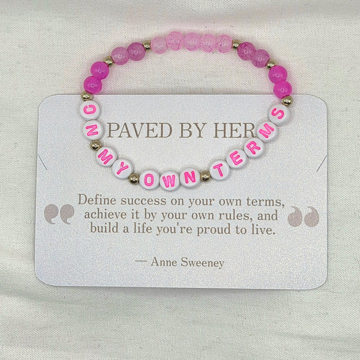 Pink beaded bracelet with 'ON MY OWN TERMS' letter beads, displayed on inspirational card.
