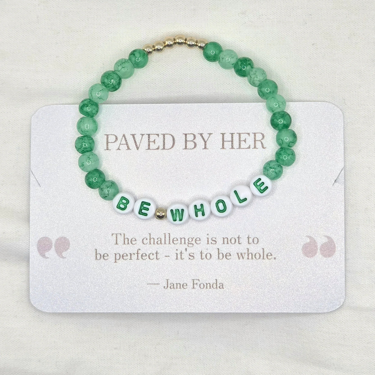 Green beaded bracelet with 'BE WHOLE' letter beads, displayed on a card with inspirational quote.