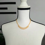 Gold chainmaille necklace with interlocking rings displayed on a mannequin, handmade jewelry for everyday wear.