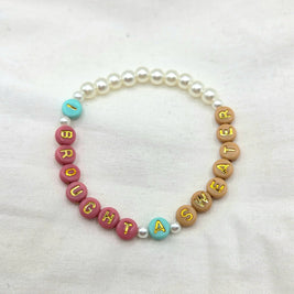 I bought a sweater beaded bracelet with colorful letter beads and pearls on white fabric
