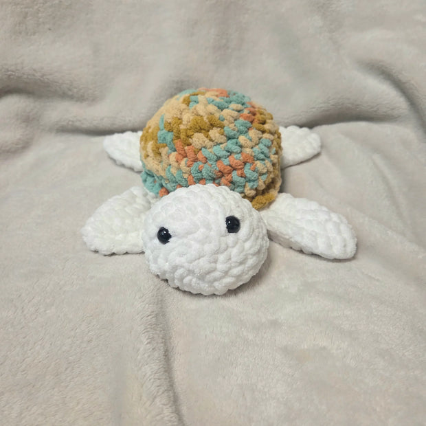 Handmade crochet turtle with colorful shell on soft blanket