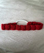 Handmade red crochet hair tie with white elastic on light fabric background