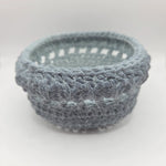 Handmade gray crochet basket with textured weave, perfect for cozy home decor or gifting.
