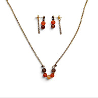 A jewelry set featuring a bronze chain necklace and matching drop earrings with small orange, brown, and red beads, displayed on a clean white background.