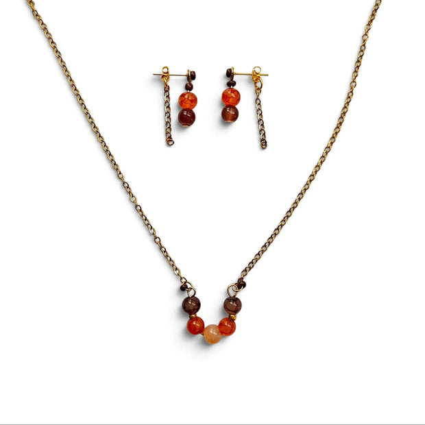 A jewelry set featuring a bronze chain necklace and matching drop earrings with small orange, brown, and red beads, displayed on a clean white background.