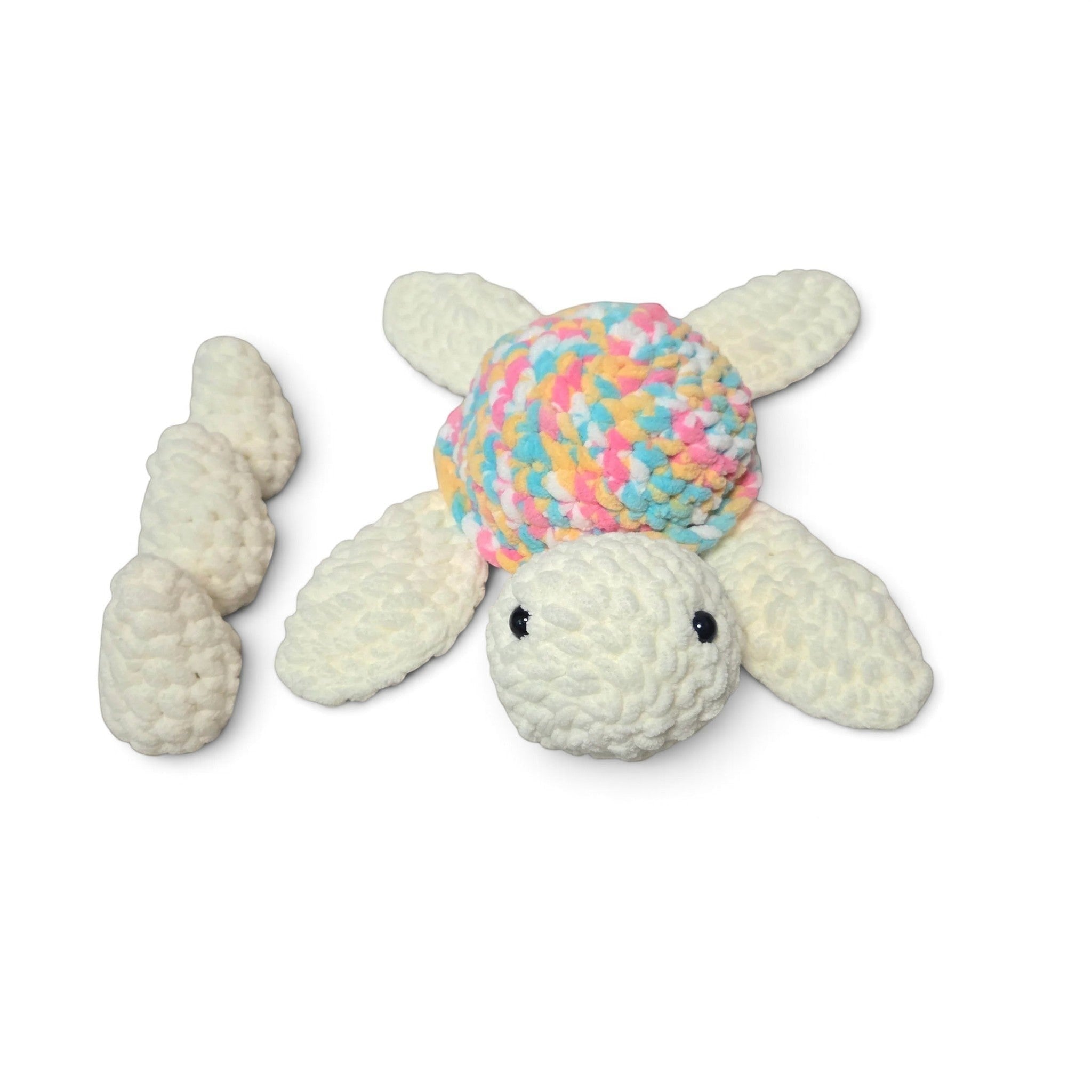 Handmade crochet turtle with pastel shell, cozy baby gift on soft blanket