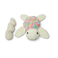 Handmade crochet turtle with pastel shell, cozy baby gift on soft blanket