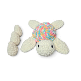 Handmade crochet turtle with pastel shell, cozy baby gift on soft blanket
