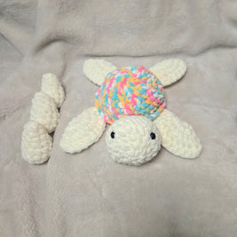 Handmade crochet turtle with colorful shell on soft blanket