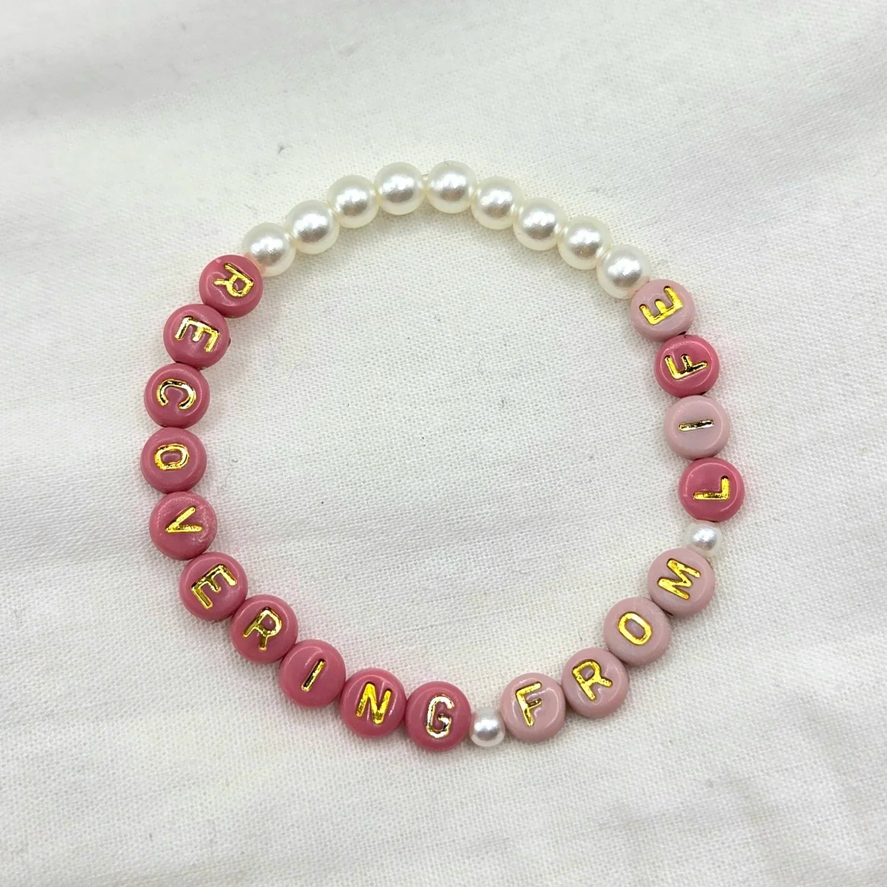 Pink and pearl beaded bracelet with 'RECOVERING FROM' in gold letters, handmade comfort accessory