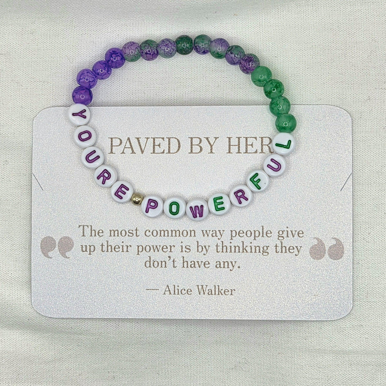 You're Powerful beaded bracelet with purple and green beads on a card with inspirational quote