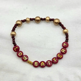 Handmade 'LOW BATTERY' beaded bracelet with burgundy and gold beads, cozy gift for creative souls