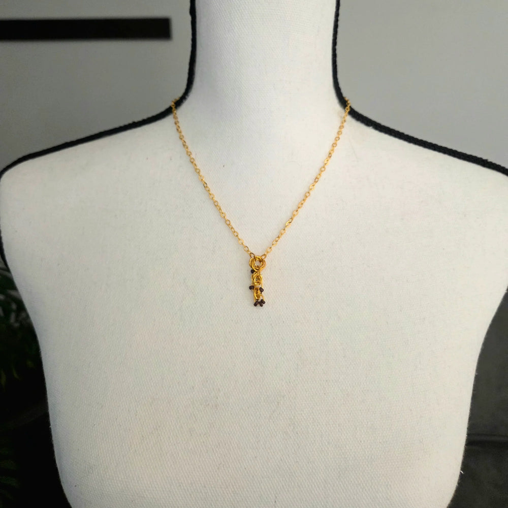 Gold chain necklace with beaded pendant on mannequin, handmade jewelry for everyday wear