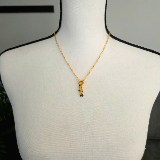 Gold chain necklace with beaded pendant on mannequin, handmade jewelry for everyday wear