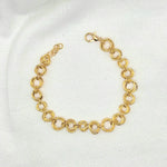 Gold tone interlocking circle bracelet with lobster clasp on white fabric background
