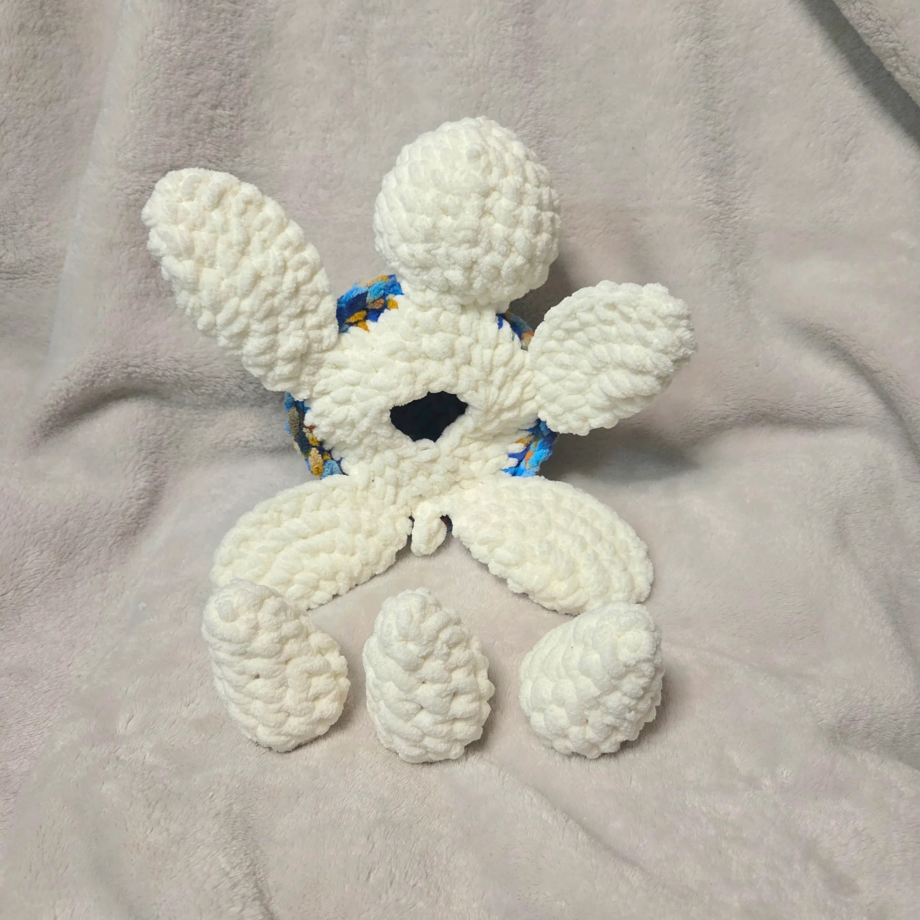 Handmade white crochet octopus with blue floral accents, cozy plush toy for comfort and creativity